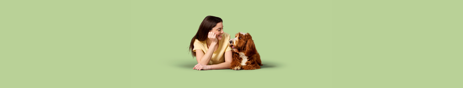 A woman and a dog lying down and looking at each other