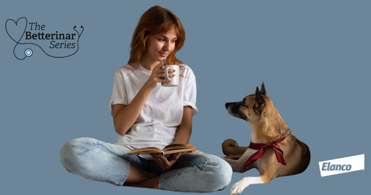 Lady reading book, sipping tea and looking at dog