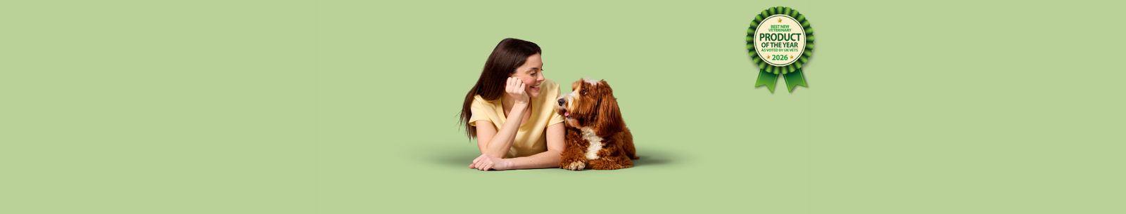 A woman and a dog lying down and looking at each other