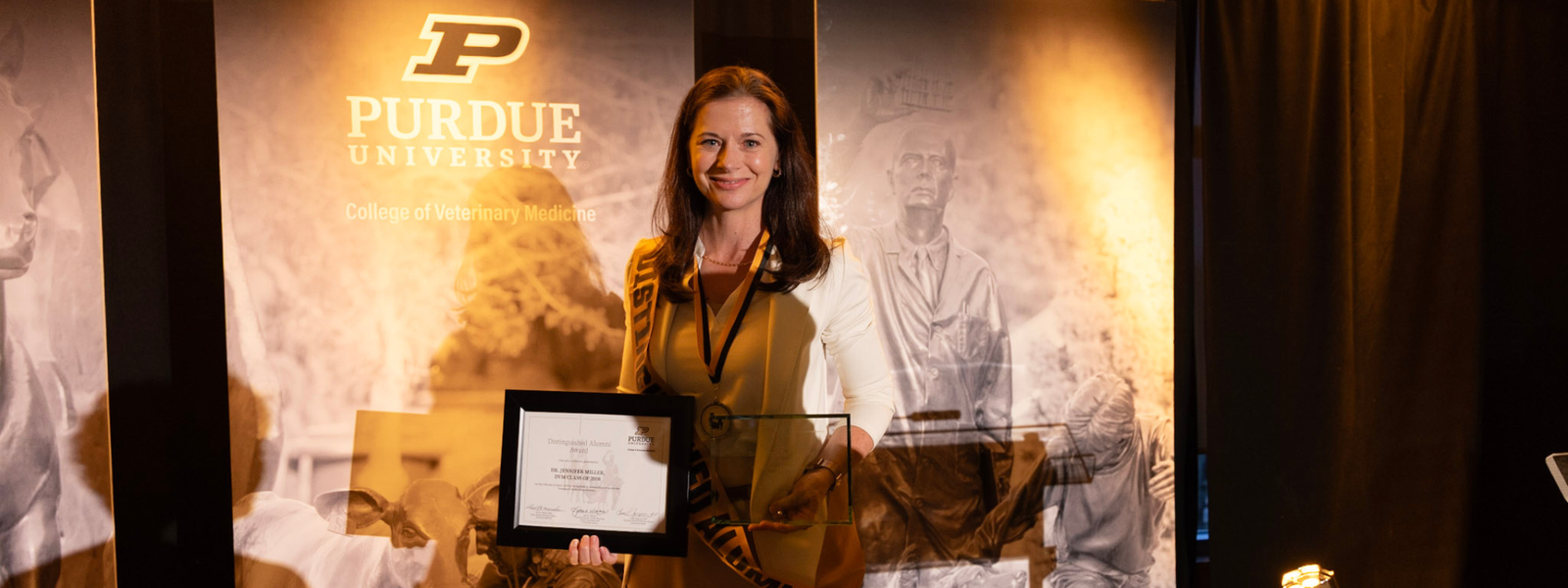 A woman standing with an award.