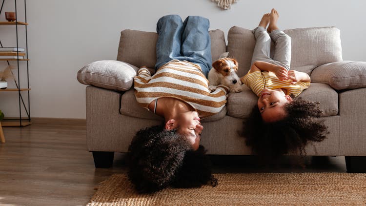 Mom, daughter and dog on a couch