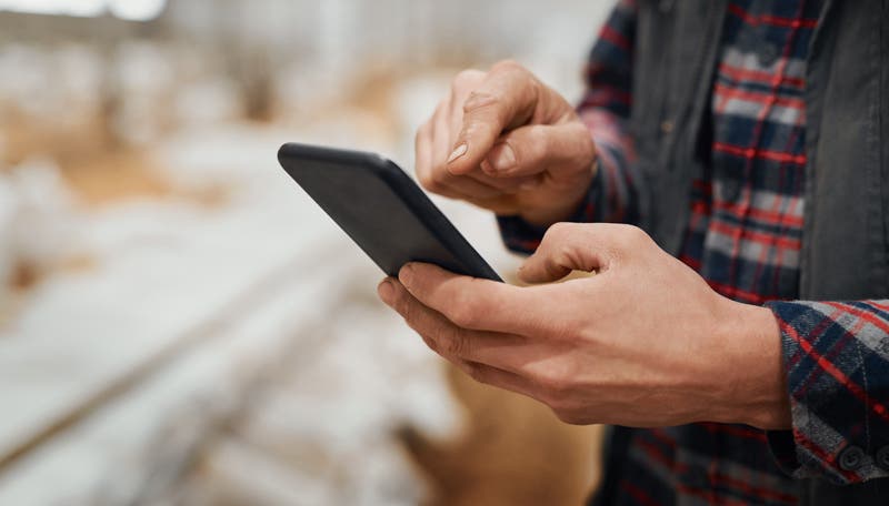 Man using cell phone in poultry house