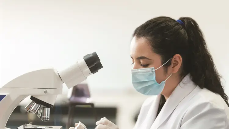 Technician looking at lab samples with a microscope