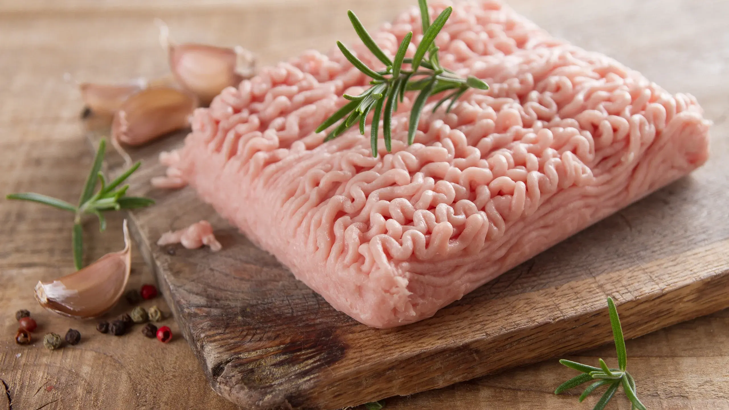 Raw grinded turkey meat with garlic and sage decoration on top