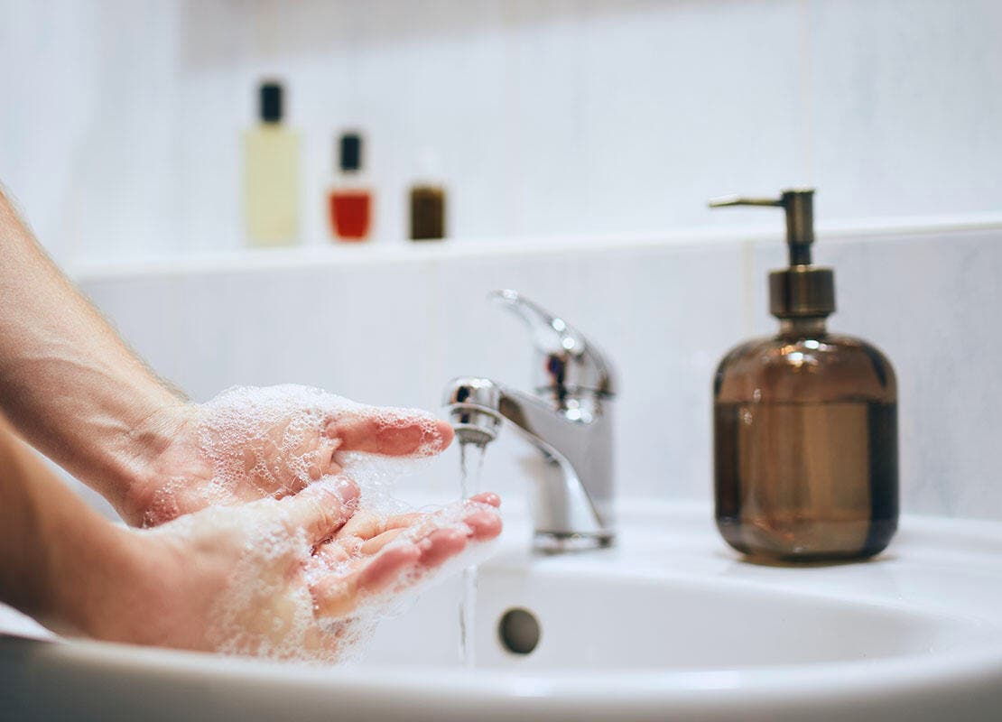 Person cleaning hands after removing tick from dog