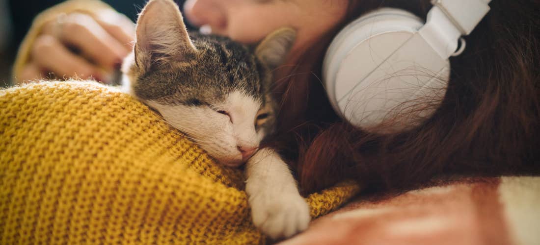 En flicka som klappar en kattunge 