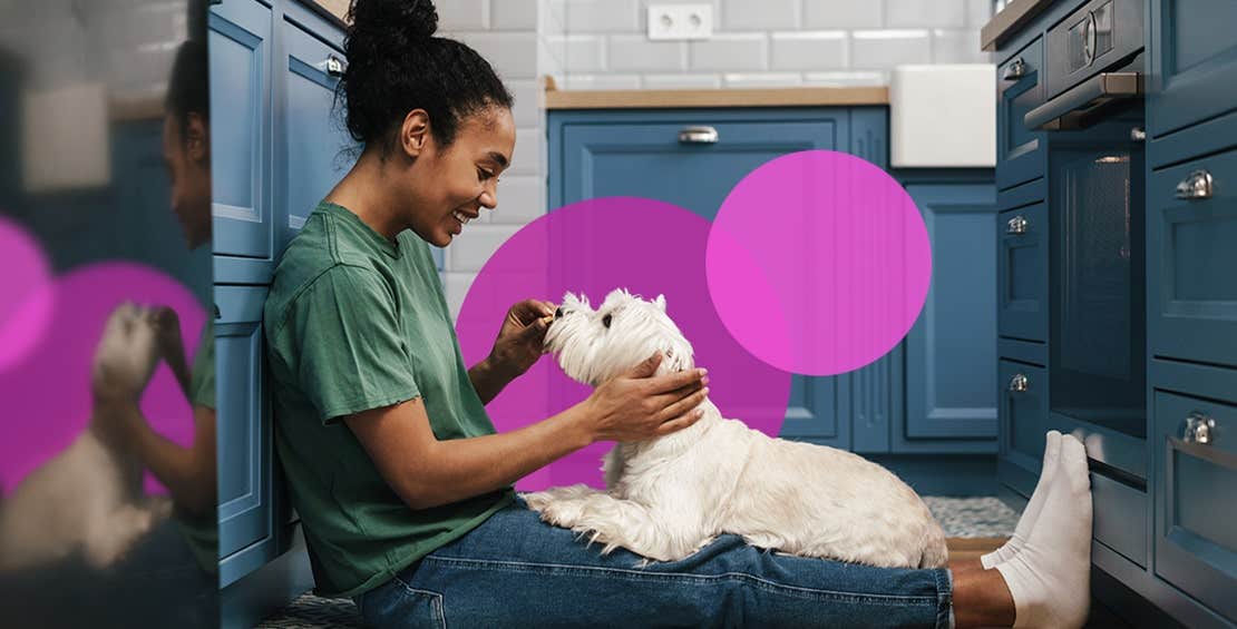 Girl playing with white dog in kitchen