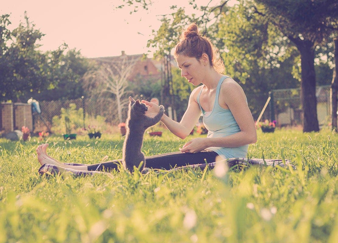 kitten_en_baasje_spelen_op_kleed_in_tuin