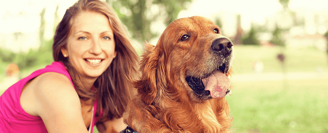 Happy female owner with content golden retriever